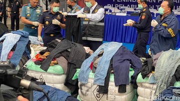 Menteri Keuangan Purbaya Yudhi Sadewa memamerkan baju bekas impor ilegal sitaan Ditjen Bea Cukai. Foto: Heri Purnomo/detikFinance
