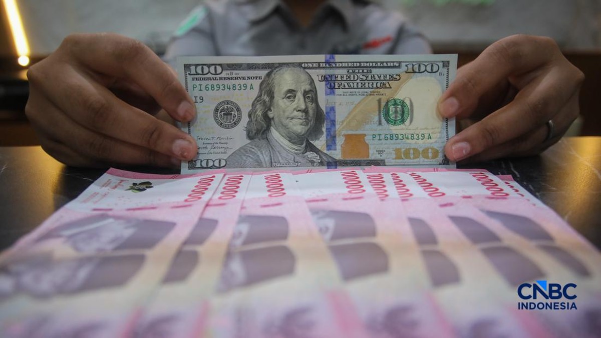 Foto: Petugas menjunjukkan uang pecahan dolar Amerika Serikat (AS) dan rupiah di Dolar Asia Money Changer, Jakarta, Rabu (8/7/2026). (CNBC Indonesia/Faisal Rahman)
